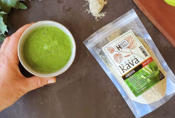 Hand holding Smoothie with bag of Green Kava.