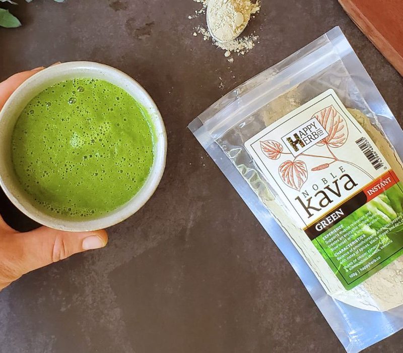 Hand holding Smoothie with bag of Green Kava.